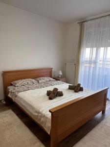 a bedroom with a bed with two teddy bears on it at Apartman San in Ruma