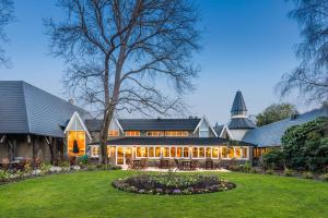 eine Außenansicht eines Hauses mit Hof in der Unterkunft Chateau On The Park - Christchurch, A Doubletree By Hilton in Christchurch