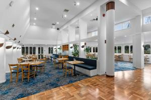 a restaurant with tables and chairs in a room at Chateau On The Park - Christchurch, A Doubletree By Hilton in Christchurch