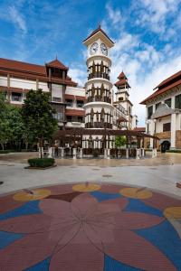 une tour d'horloge en face d'un bâtiment avec une fresque florale dans l'établissement DoubleTree by Hilton Putrajaya Lakeside, à Putrajaya