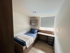 a small bedroom with a bed and a window at Sabaneta Apto tres habitaciones a 10 minutos CC Mayorca in Sabaneta