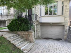 a house with a garage and a driveway at One Deluxe Bedroom Suite in Midtown in Toronto