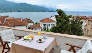 Una mesa con un plato de comida y bebidas en un balcón. en Jovanovic Guest House, en Ohrid