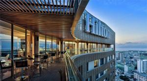 岘港Hilton Da Nang的一座带桌椅阳台的建筑