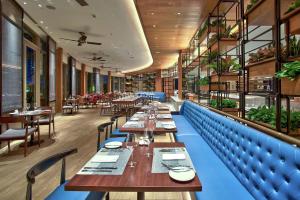 Hilton Da Nang في دا نانغ: غرفة طعام مع طاولات وكراسي طويلة