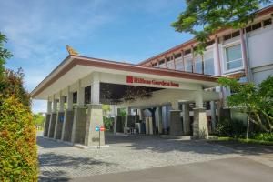 un edificio con un cartel delante en Hilton Garden Inn Bali Ngurah Rai Airport, en Kuta