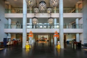eine große Lobby mit Kronleuchtern und Lichtern in einem Gebäude in der Unterkunft Hilton Garden Inn Bali Ngurah Rai Airport in Kuta