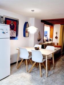 a kitchen and dining room with a table and white chairs at Vivienda Vacacional Parque Santiago 1 Bernal Home in Arona