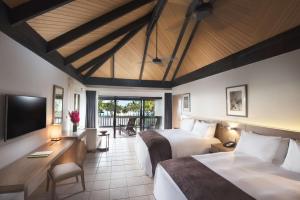 una camera d'albergo con due letti e una televisione di DoubleTree by Hilton Fiji - Sonaisali Island a Nadi