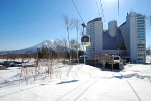 a ski lift with snow and a building at Hilton Niseko Village in Niseko