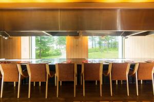a dining room with a table and chairs and a large window at Hilton Niseko Village in Niseko +55 photos