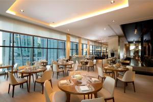 a restaurant with tables and chairs and windows at Conrad Seoul in Seoul