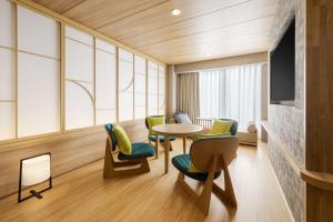 um quarto com uma mesa e cadeiras, uma mesa e janelas em Hilton Garden Inn Kyoto Shijo Karasuma em Quioto