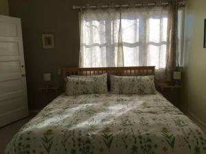 a bedroom with a bed with a floral bedspread and a window at Historic Clarkdale apartment #104 in Clarkdale