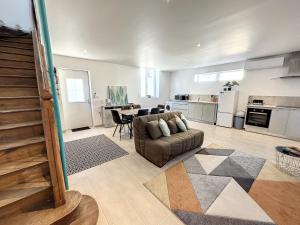 ein großes Wohnzimmer mit Couch und Tisch in der Unterkunft Maison Vue Pyrénées Centre ville - salle de jeux in Saint-Gaudens