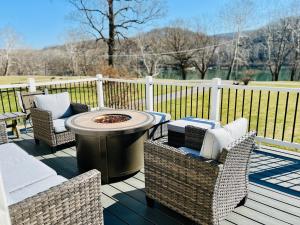 a patio with wicker chairs and a fire pit on a deck at Riverfront House in Harpers Ferry in Harpers Ferry
