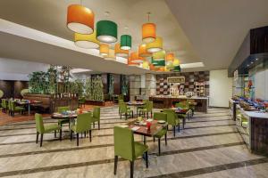 un restaurante con mesas y sillas en una habitación en DoubleTree by Hilton Gurgaon New Delhi NCR, en Gurgaon