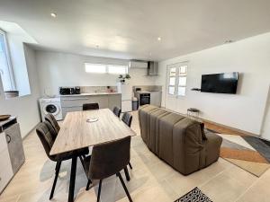 eine Küche und ein Wohnzimmer mit einem Tisch und einer Couch in der Unterkunft Maison Vue Pyrénées Centre ville - salle de jeux in Saint-Gaudens + 7 Fotos