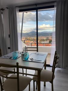 a dining room table with a view of a city at Suits Mirador de Luz in Cuenca