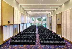 an empty room with black chairs in a building at DoubleTree by Hilton Ahmedabad in Ahmedabad