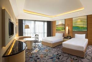 a hotel room with two beds and a couch at DoubleTree by Hilton Ahmedabad in Ahmedabad
