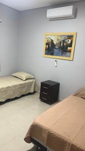um quarto com duas camas e uma foto na parede em Linda casa em condomínio fechado em Brasília