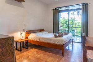 um quarto com uma cama e uma grande janela em Mot Mot Vacation em Sámara