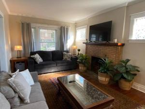 a living room with a couch and a fireplace at Beautifully remodeled house 1.5 miles from falls. in Niagara Falls