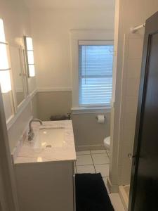 a bathroom with a sink and a toilet and a window at Beautifully remodeled house 1.5 miles from falls. in Niagara Falls +12 photos