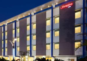 a hotel with a sign on the side of a building at Hampton by Hilton Vadodara-Alkapuri in Vadodara