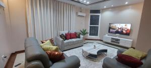 a living room with a couch and a tv at Sami BnB - Apt 02 Makongo after Mlimani City in Dar es Salaam