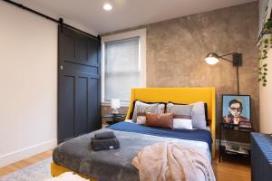 a bedroom with a large bed with a yellow headboard at Urban Bedroom in Mount Vernon +1 photo