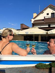 two people in a swimming pool with glasses of wine at Luxury Apartments 88 in Smederevo