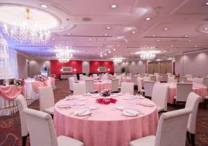 a banquet hall with pink tables and chairs and chandeliers at Hilton Tokyo Narita Airport in Narita