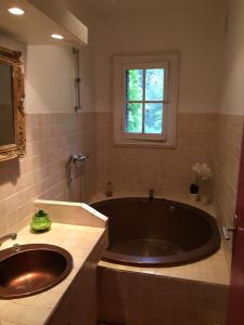 a bathroom with a large tub and a sink at La Bellonette in Marseillan
