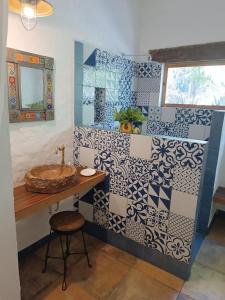 Łazienka wyłożona jest niebieskimi i białymi kafelkami oraz umywalką. w obiekcie Jungle Lodge CANCUN AEROPUERTO w mieście Cancún