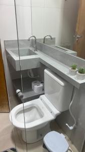 a bathroom with a white toilet and a sink at Linda casa em condomínio fechado in Brasilia