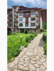 a building with a stone path in front of it at VV Apartment Bansko in Bansko