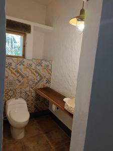niewielka łazienka z toaletą i oknem w obiekcie Jungle Lodge CANCUN AEROPUERTO w mieście Cancún
