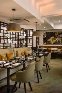 惠灵顿惠灵顿希尔顿逸林酒店的有桌椅和灯的餐厅