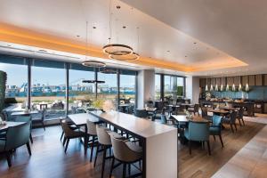 a restaurant with tables and chairs and large windows at Hilton Tokyo Odaiba in Tokyo
