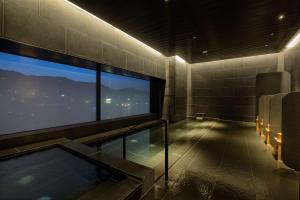 uma casa de banho com banheira de hidromassagem e uma grande janela em Hilton Nagasaki em Nagasaki
