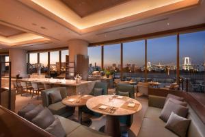 a restaurant with tables and chairs and a view of the city at Hilton Tokyo Odaiba in Tokyo