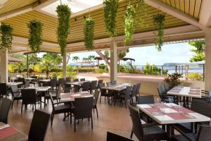 um restaurante com mesas e cadeiras e vista para o oceano em Hilton Guam Resort & Spa em Tumon
