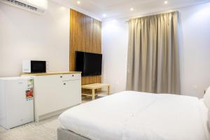 Luxury & Charming Big Apartments in Mudhainib في AR Rummanah: غرفه فندقيه سرير وتلفزيون