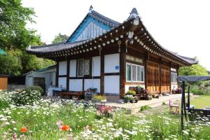 chiński dom z ogrodem przed nim w obiekcie Damyang Flower & Hanok w mieście Damyang