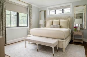 a bedroom with a large bed and a mirror at The Oaks Waterfront in Saint Michaels