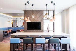 a lobby with a bar with chairs and a tv at Hampton By Hilton Aberdeen Westhill in Westhill 