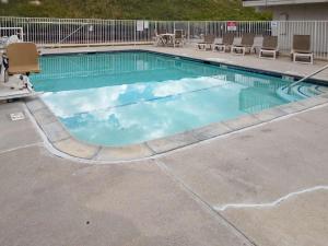 a swimming pool with blue water and clouds in it at Motel 6 Cheyenne in Cheyenne