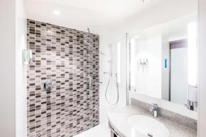 a bathroom with a shower and a sink at Hampton By Hilton Aberdeen Westhill in Westhill 